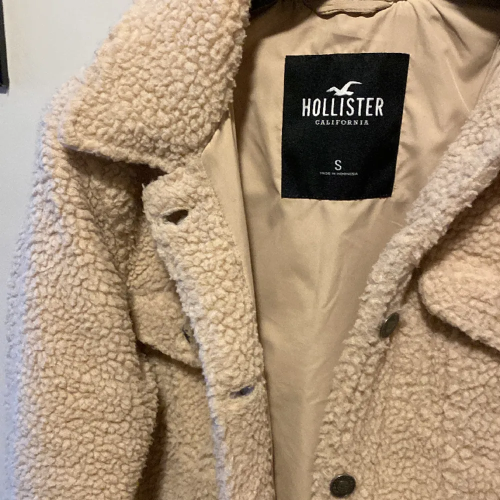 Säljer denna teddy jacka från Hollister! Med knappar och i nyskick. Storlek S  . Jackor.