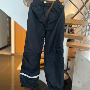 Vindbyxa  - Svart vind/överdragsbyxa i storlek 140. Den är välvårdad och i bra skick. Köpt på Åhléns. 