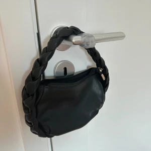 Väska  - Aldrig använd. Finns en innerficka. Flätat band