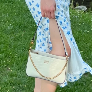 Väska  - Beige väska i jätte bra sick från guess.  Köpt för 1,2 säljer för 600kr.