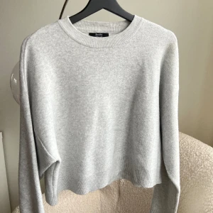 Stickad tröja - Grå stickad tröja i kortare modell. Använd några få gånger, i bra skick
