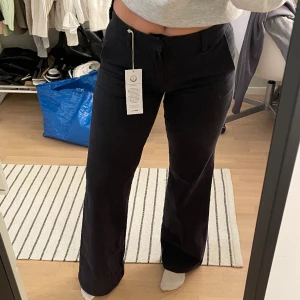 Lågmidjade byxor - Lågmidjade chinos från Gina. Stretchiga. Färgen är offblack.  Skitsnygga verkligen, råkade köpa dubbletter, därav lapparna kvar🤪 Nypris 500