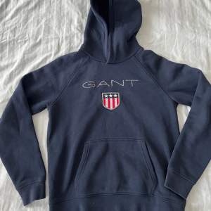 GANT shield logo hoodie i färgen midnattsblå.  Som ny!  Storlek/barn 12-13 år   Inköpt på KidsStore 899kr.   