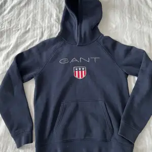 GANT shield logo hoodie i färgen midnattsblå.  Som ny!  Storlek/barn 12-13 år   Inköpt på KidsStore 899kr.   