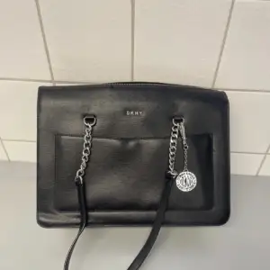 DKNY handväska, i mycket bra skick nästan som ny! Svart med silvriga detaljer