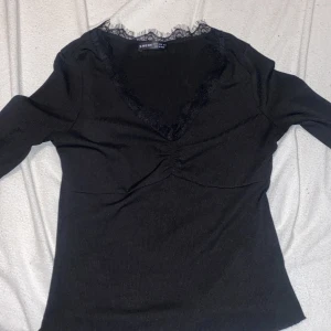 V-ringad tajt ribbad tröja  - En tajt ribbad tröja som är v ringad och har spets vid bröstet jätte fin  