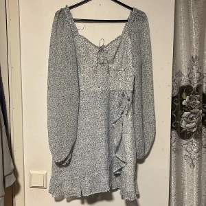 Blommig klänning  - Klänning från Hollister i storlek M, passar perfekt till midsommar! Endast använd en gång dvs i mycket bra skick! Klänningen har två rosetter (syns på bild) 