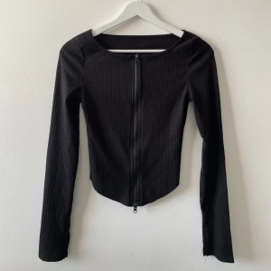 Svart tröja med dragkedja  - Slits i armarna, använd ett fåtal gånger