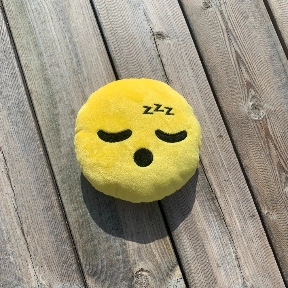 Liten mjuk prydnadskudde med ett sovande emoji ansikte. Endast legat i en kasse.  Höjd och längd är ca 6,5 cm.. Övrigt.