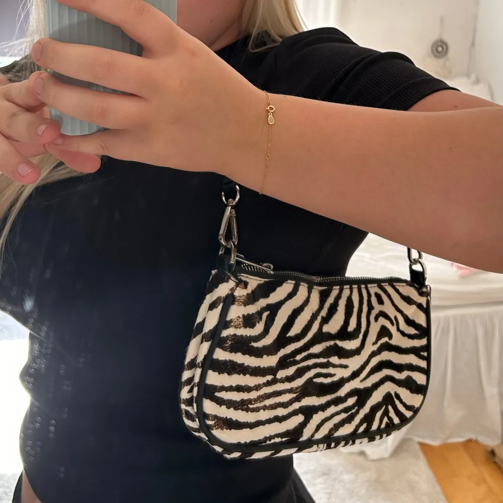 Superfin väska i zebra mönster från Zara. Köpte väskan för några år sedan och den är använd under en sommar. Den är i bra skick men mönstret har skavts bort lite på ena sidan. . Väskor.