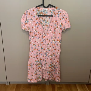 Blommig sommarklänning  - Blommig kort sommarklänning med knappar. 