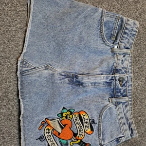 Snygg ed hardy kjol - En fin Ed Hardy minikjol som passar perfekt till sommar. Har används en gång innan men annars är den som hel ny!  Midjan är 34cm o längden är 32cm 