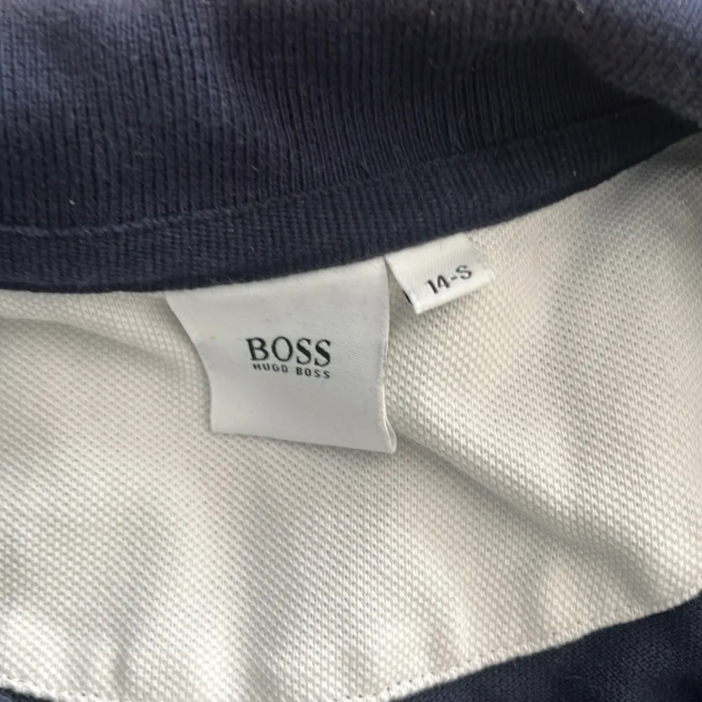 En Hugo boss piké med storleken 14-S,är i ganska bra skick, har inte använt så många gånger för den har blivit för liten och försöker bara få bort med den.. Tröjor & Koftor.