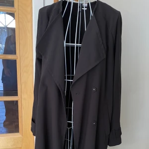 Trenchcoat - Ledig modell med knäppning fram, saknar bältet