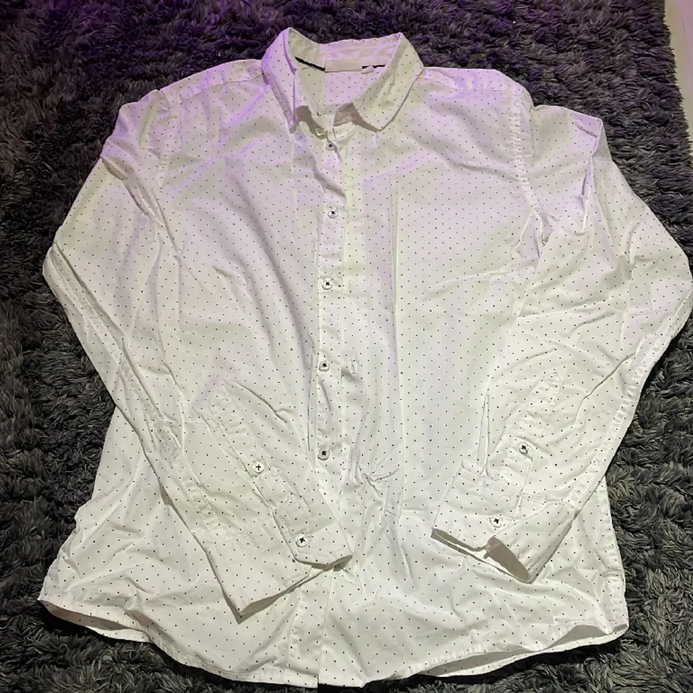 Skjorta från Kappahl i färgen vit med svarta prickar. Använd endast få gånger och är i ett mycket bra skick. Inga tecken på användning alls.. Skjortor.