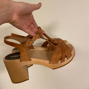 Hasbeens sandaler - Chunky träklackar från det svenska kvalitetsmärket ”swedish hasbeens”. Läderremmen runt ankeln är justerbar och de har aldrig blivit använda. Originalpris är 2500kr. Säljer åt min mamma då de inte passade henne.