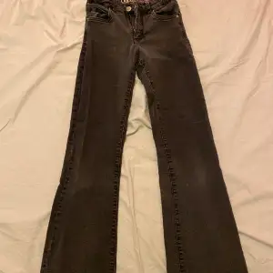 Ett par bootcut jeans va från början svarta men dom har bleknat lite men ser ändå bra ut