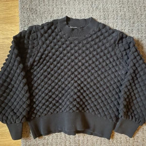 Svart topp/tröja - Svart snygg topp, så cool textur? (Ser bättre ut på) Använder för sällan, därav försäljning. Står storlek L men snarare M. Lite kortare i modellen.
