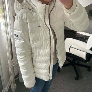 Vit Tommy Hilfiger jacka   - Säljer denna fin vinterjacka för den inte kommer till användning. Orginal pris 3000 kr. Jackan är i storlek M men den är liten i storlek då den sitter väldigt bra på mig som bär storlek Xs vanligtvis. 