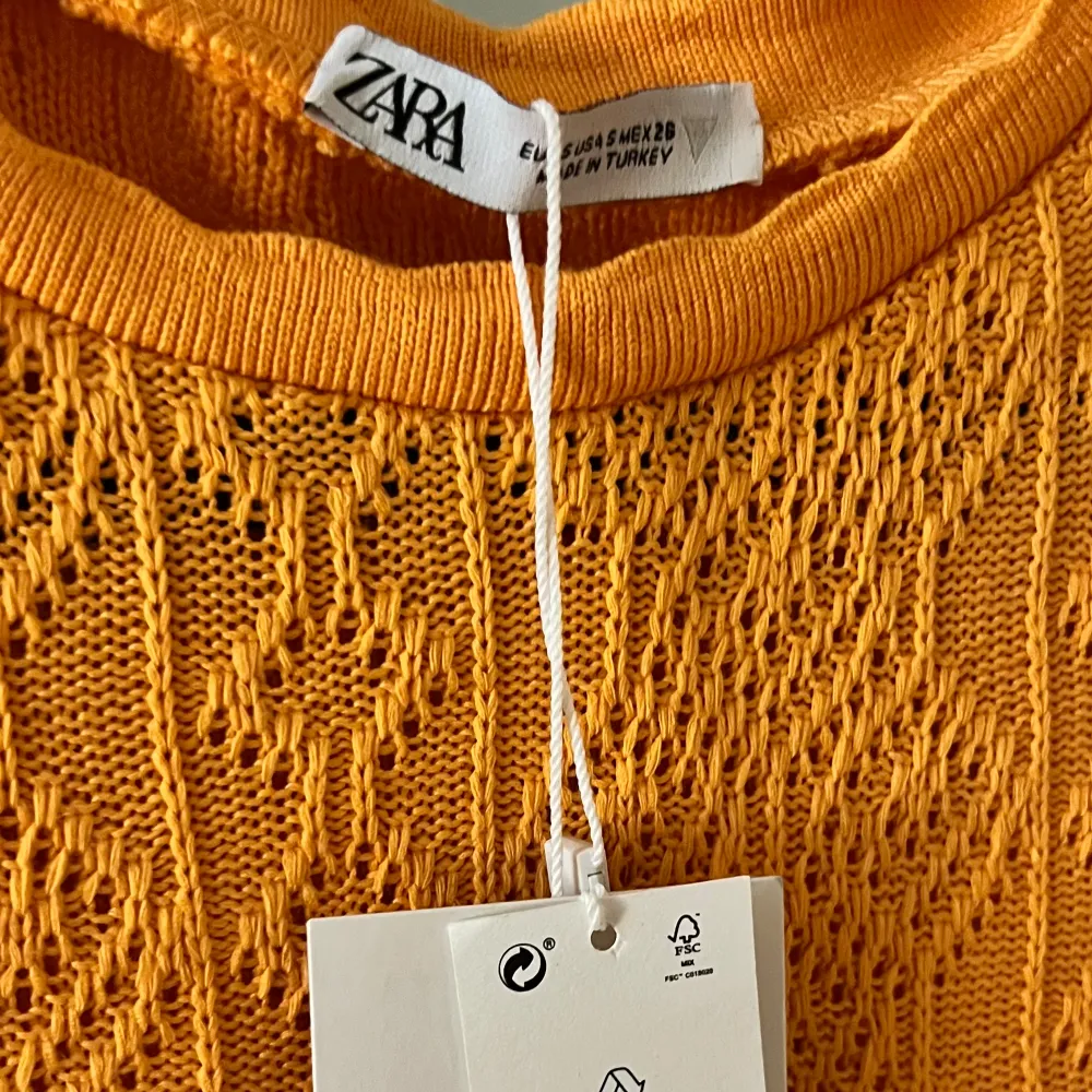 Virkad/stickad tröja från Zara, helt oanvänd med prislapp kvar och säljs inte längre då den köptes 2022. Assnygg till sommaren med en bränna och jeansshorts🧡🧡lägg gärna prisförslag!. T-shirts.