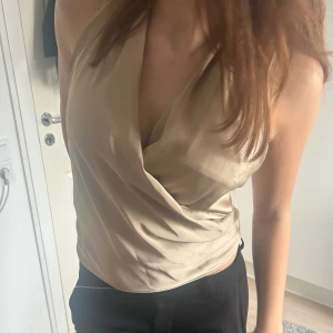 Zara fest topp - Jättefin festlig topp i silkesmaterial, beige! Storlek M men passar även S! Endast använd en gång och den har inga defekter! Den är öppen i ryggen vilket är super fint!