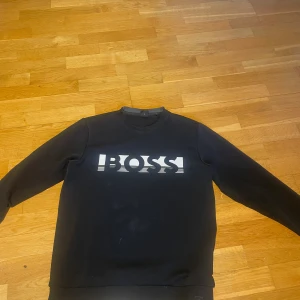 Hugo boss tröja - Den passar mig inte och rensar ut. Den är i bra skick utom att texten är lite sprucket. Den sitter bra i storlek. Om du har frågor är det bara att skriva