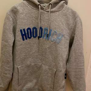 Varm och bekväm Hoodrich hoodie i färgen grå men en Text som går från mörkblå till ljusblå Köpt för 800 Pris kan diskuteras