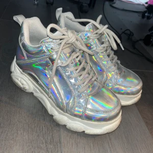 Buffalo Corin Mirror PU - Jättefina holografiska skor från buffalo med en chunky sula. Det har tecken på användning då jag använt dem en hel vår säsong men det är inget fel på dem eller att de är trasig mest att sulan är lite smustig vilket går att lösa!