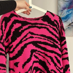 Stickad tröja  - Storlek s En rosa/svart stickad tröja. Inte med materialet som sticker! Väldigt stretchig 