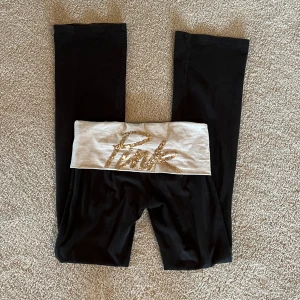 Pink Victoria's Secret yoga byxor  - Pink Victoria's Secret yoga byxor! Utsvängda och lådmidjade, lite slitna vid bena och vid skrevet men inget som märks! Midja: 36cm, innerben: 84cm, ytterben: 100cm