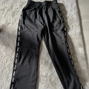 Svarta Stronger mjukisbyxor - Svarta mjukisbyxor från Stronger. Hög midja, två fickor, dragkedja i byxbenet att dra upp ca 10 cm. Bra skick 