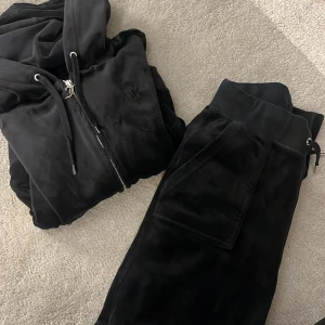 svart juicy couture set - säljer mitt svarta juciy sett pågrund av att det ej kommer till användning, inga hål eller defekter förutom att på koftan så har silver detaljer lossnat och juicy dragkedjan även rostat lite därav det priset. Skriv privat för fler bilder.