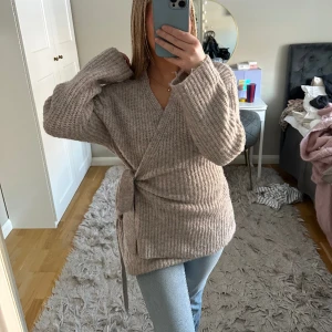 Mysig kofta - Beige/grå stickad kofta som går omlott som man knyter på sidan🥰