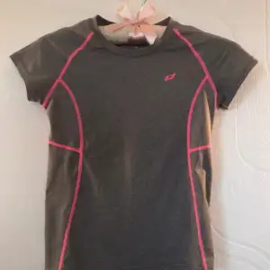 Fin grå T-shirt med rosa sömmar som passar perfekt för till exempel idrott eller träning. Jätte skön och inte använd så mycket så den är i bra skick. Från märket PRO TOUCH i storleken 122/128.