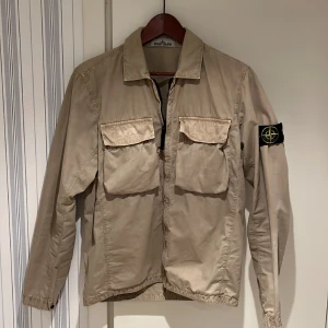 Stone Island Overshirt - Tjena! Säljer nu min riktigt feta overshirt från Stone Island.  Storlek M, sitter perfekt på mig och är 183 cm! Har en fläck på bröstet därmed priset. Självklart äkta, kvitto finns!