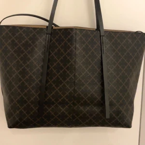 By Malene Birger väska - Jätte fin väska från By Malene Birger i modellen ”Abigail printed tote bag” i färgen ”Dark Chokolate” som jag nu säljer pga att den inte riktigt kommit till användning! Den är köpt i butiken ”Debut”! Dustbag medföljer, skickar fler bilder vid intresse!