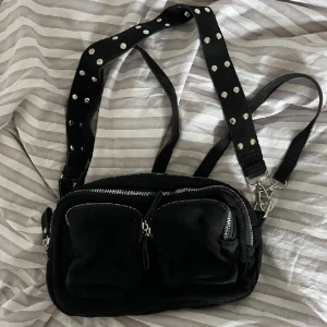 Svart väska - En trendig,snygg axelremsväska med silvriga detaljer! Använd en gång💘