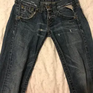 Mörk blåa låg midjade jeans med broderi på baksidan.