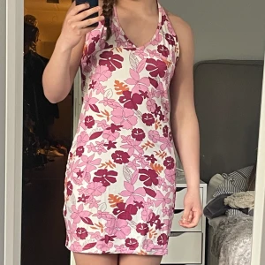 Blommig halterneckklänning - Rosablommig halternecklänning, originellt från shein men köpt på plick. Storlek XL men sitter som en vanlig flowig klänning. Har sömmar där brösten ska gå men man kan knyta baktill hur högt man vill. Använd men bra skick!⭐️