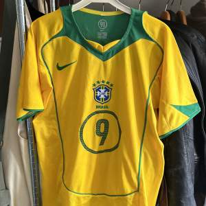 Brasilien 2004 hemma tröja. Den är knappt använd och i fint skick. Vid frågor eller funderingar är det bara att skriva.