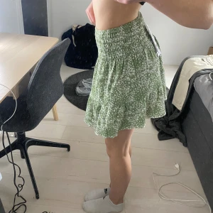 Grön kjol från ginatricot - Grön och mönstrad kjol från Ginatricot. Låg midja. Oanvänd.