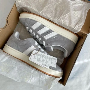 Grå adidas campus  - Säljer dessa helt nya och oanvända adidas campus med lappar och låda kvar! Skulle också säga att de är lite stora i storleken då de passar mig som vanligtvis har 37❤️ (grå skosnören ingår också)  