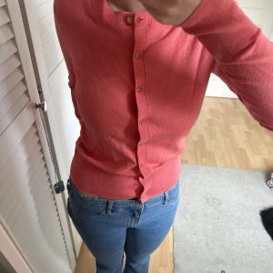 Stickad kofta - Korallfärgade kofta från Lindex. Jättefin passform och i nyskick. 