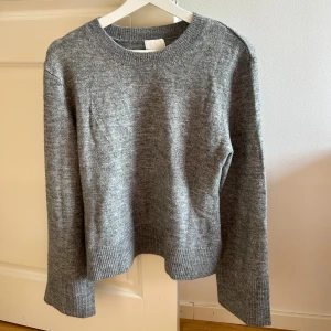 Stickad tröja - Utsvängda armar