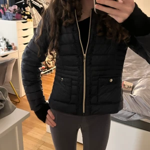 Snygg vår/höst jacka - Super fin vår/höst jacka från saki i mörkblå med guld detaljer. Säljer då den ej kommit till användning! Nypris: 1700kr. Postar om annonsen!!