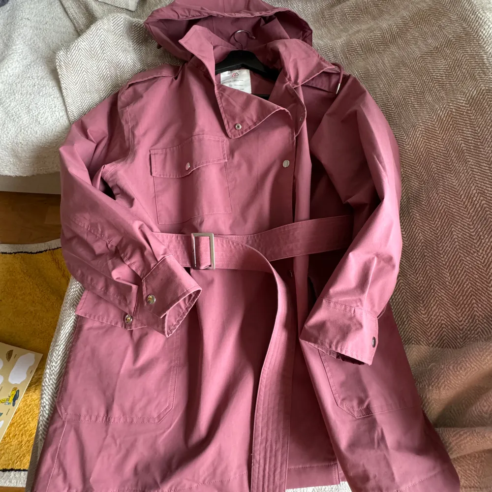 Next Rainwear collection Trench raincoat with hood dusty pink colour Size 16/44, looks great as oversized for smaller size 170/100A Shell - 55% polyester, 45% cotton Lining - 100% polyester  Very good condition. Jackor.