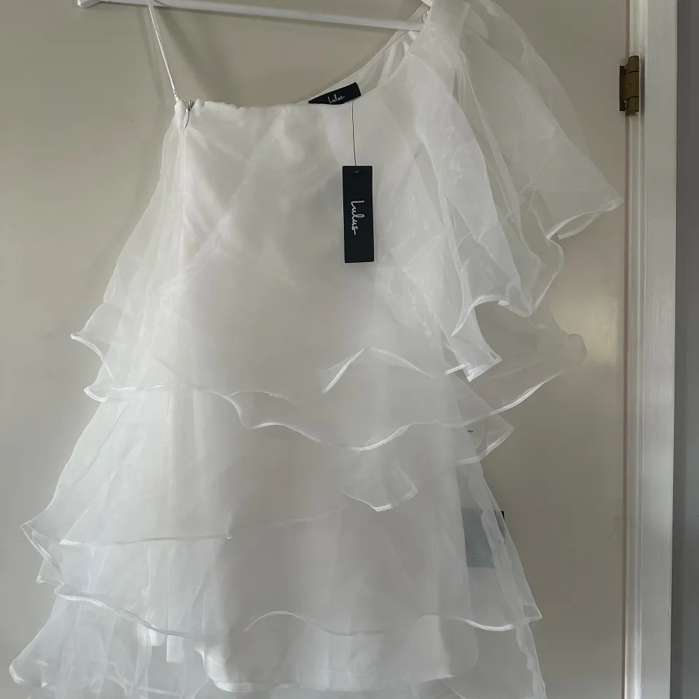 En väldigt fin vit volang klänning ifrån märket Lulus. Klänning är i storlek xs och är helt ny med prislappar på. Köpte den av en här på Plick men är endast testad!💓💓(Lånad 1a bild)!! Säljer denna då den inte passade mig . Klänningar.