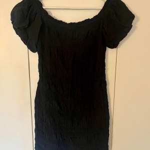 Svart smocked klänning från HM i storlek M, oanvänd.
