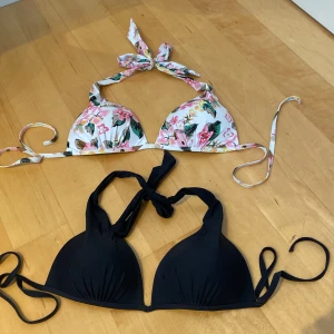 Bikini överdel - 2 fina bikini överdelar med knyten. En svart och den andra vit med fina blomster- detaljer. Använda få gånger och är i fint skick. 