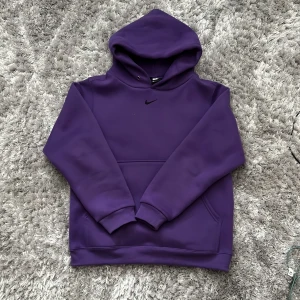 Nike Swoosh Hoodie (Lila) Storlek M 100% Cotton - Detta är en av de skönaste hoodiesana jag ska inte ljuga. Den är jätte tjock och fluffig, luvan är dubbel lagrad och den är 100% cotton. Säljer den endast för har inget som passar med lila just nu, men den är verkligen tvär bra och utmärkt skick. Mvh